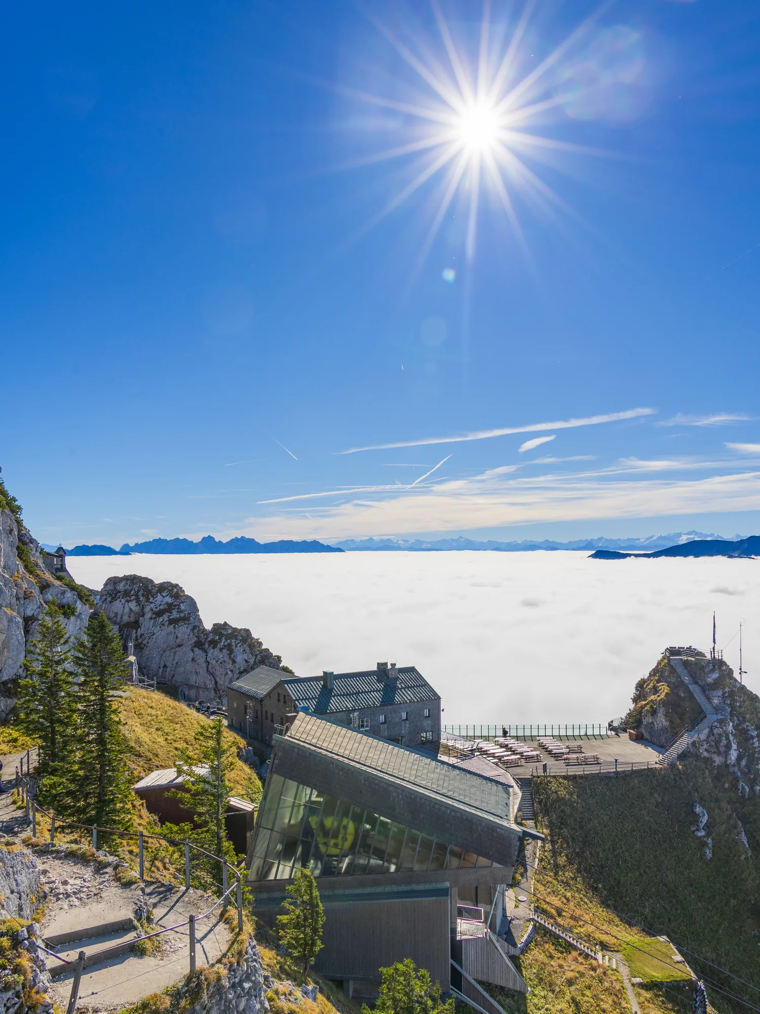 Bergstation über einem Nebelmeer unter sonnigem Himmel