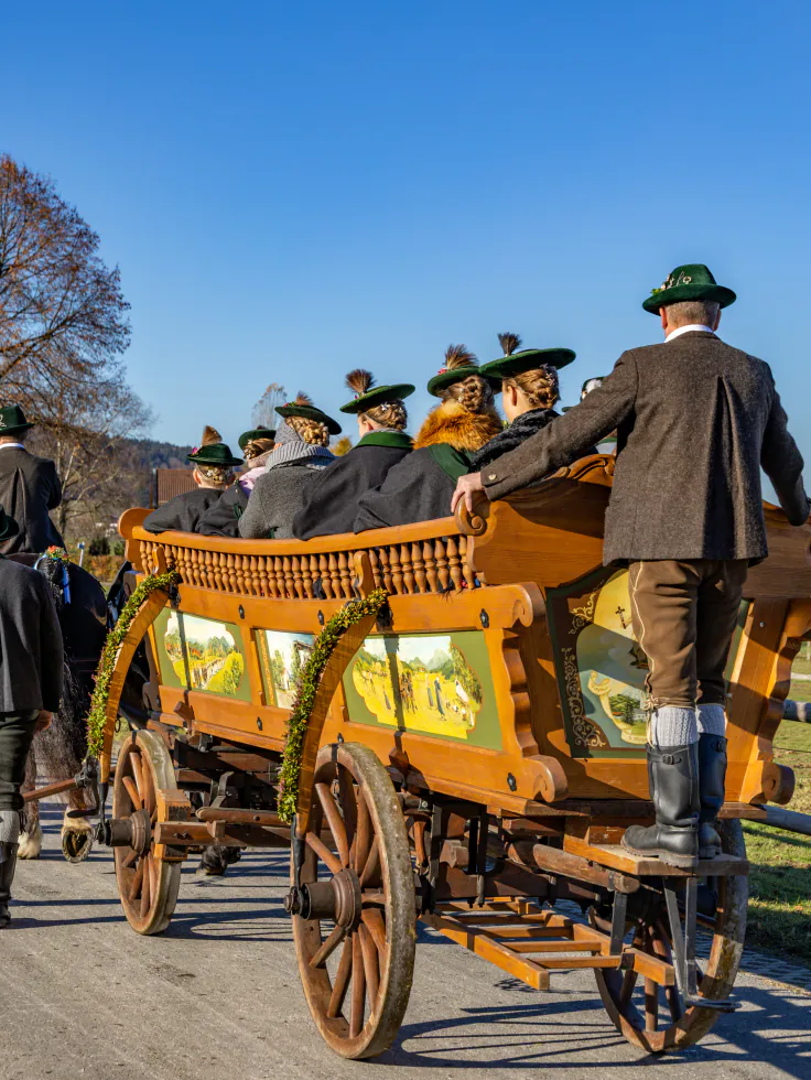 Bemalter Truhenwagen, die Mitfahrer in Tracht